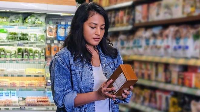 person checking label on package of processed_food